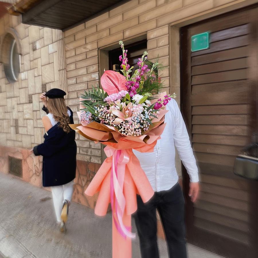 Veliki buket s anturijem i roze cvijećem, nošen ulicom